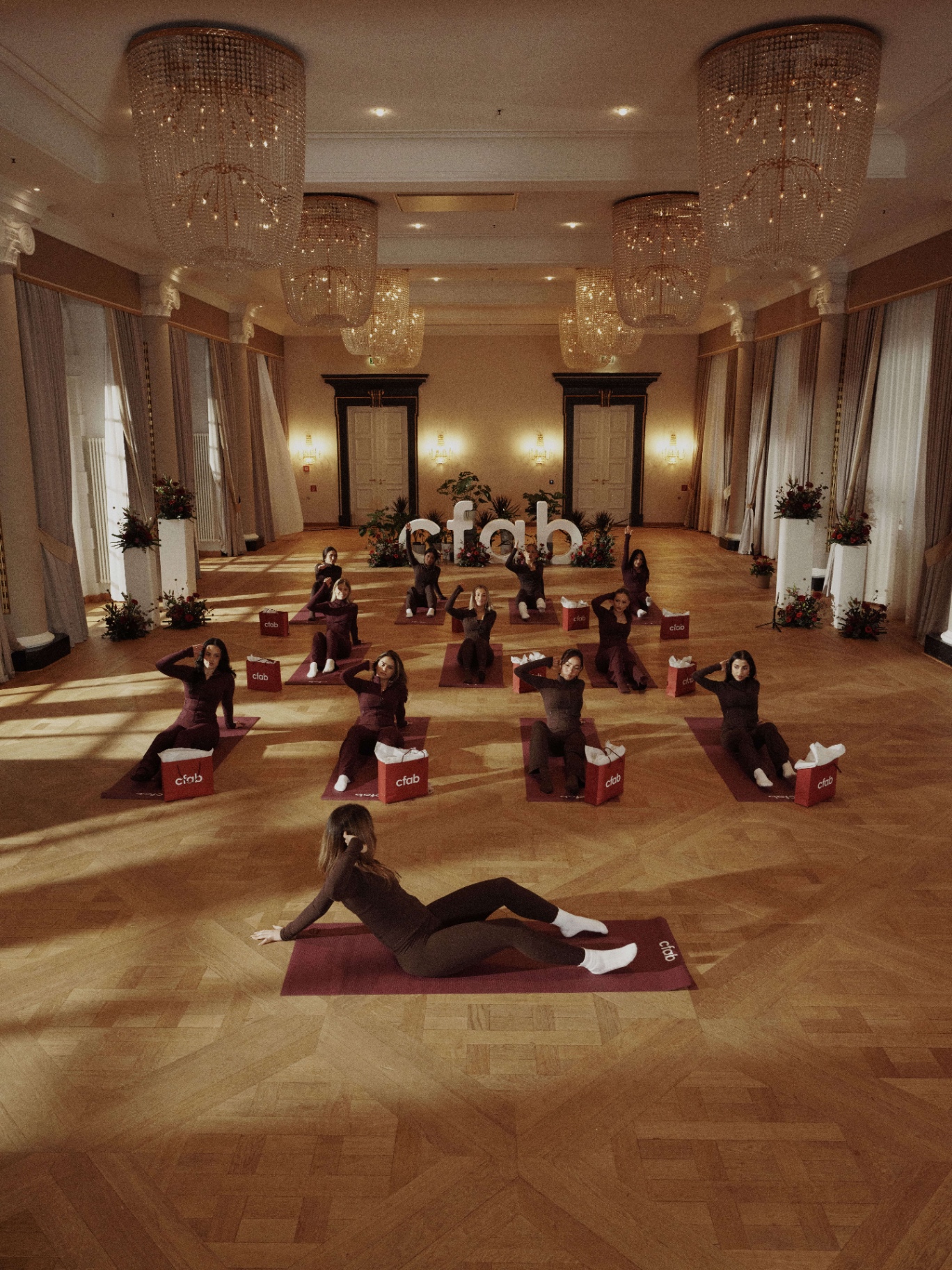 Influencer yoga class staged in the chandeliered ballroom of Schloss Bensberg for the cfab Yoga Collection